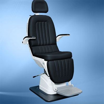 NTC-1400 Power Tilt Examination Chair on a blue background. Examination chair has black cushions with a white frame and silver footrest.